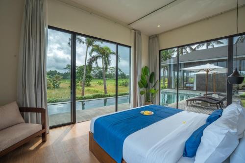 a bedroom with a large bed and a large window at 4BR Rice Fields view & Spa Villa Abian in Sukawati