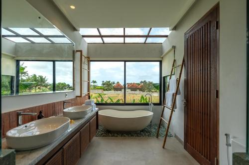 a bathroom with two sinks and a large window at 4BR Rice Fields view & Spa Villa Abian in Sukawati
