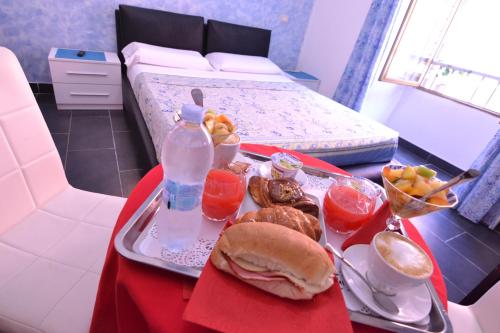 a tray of food on a table next to a bed at Gio' Suites in Rome