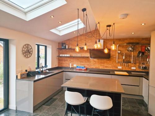 a kitchen with a counter and chairs in it at 5 star Luxury Home in a Magnificent area -Chester in Hough Green