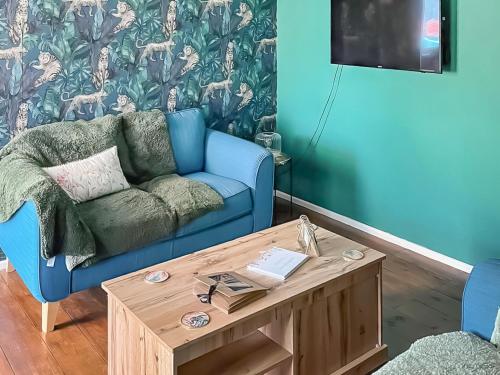 a living room with a blue couch and a coffee table at Garden Cottage in Pakefield