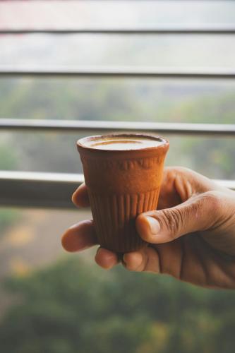 a hand holding a cup of coffee at Nahargarh view Hotel in Jaipur