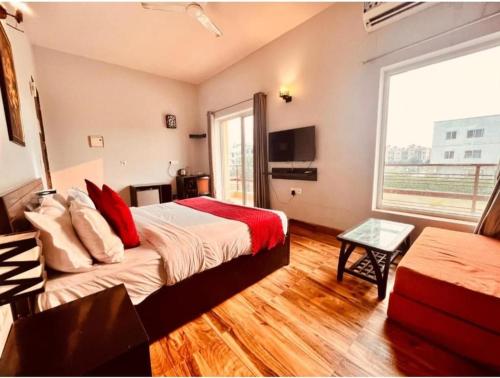 a hotel room with a bed and a large window at Brijwasi Bhavan vrindavan Omax in Chhatikara