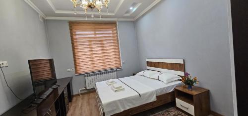 a small bedroom with a bed and a window at PrestigeVilla in Akchiy