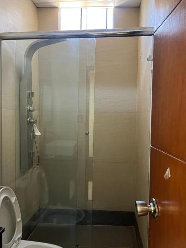 a bathroom with a glass shower with a toilet at Hospedaje bolognesi in Piura