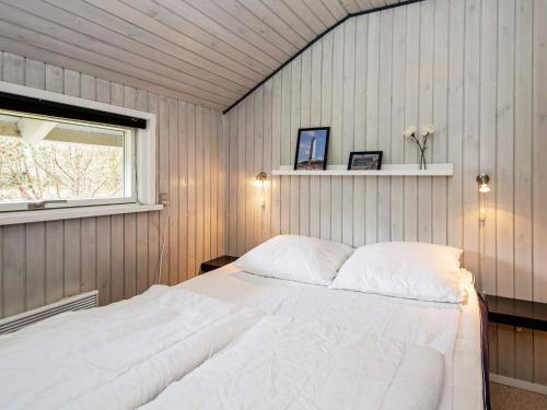 a bedroom with a white bed in a room with a window at Secluded Retreat in Nature - By Traum Ferienwohnungen in Blåvand