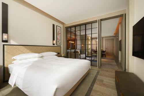 a bedroom with a large white bed and a balcony at Park Hyatt Niseko Hanazono in Kutchan