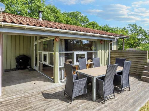 a patio with a table and chairs on a deck at 6 person holiday home in Hadsund-By Traum in Øster Hurup