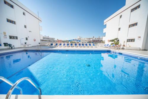 a large swimming pool in front of two buildings at Sun Beach in Santa Ponsa