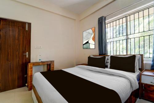 a bedroom with a large bed and a large window at Super Collection O Calicut Near Calicut Medical College in Kakkayam