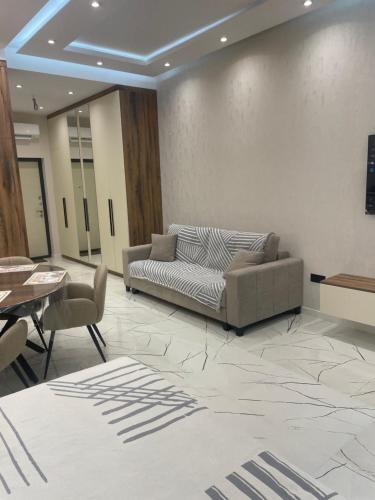 a lobby with a couch and a table and chairs at Sea breeze, studio apartment in Nardaran