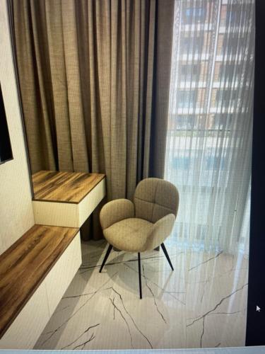 a chair sitting in front of a window at Sea breeze, studio apartment in Nardaran