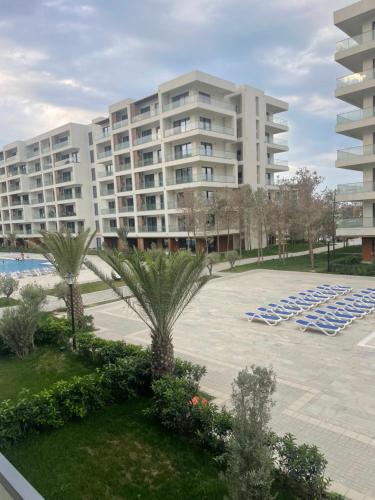 a large apartment building with lounge chairs and a pool at Sea breeze, studio apartment in Nardaran