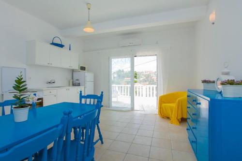 a kitchen with a blue table and chairs in a room at Villa Lav in Prigradica
