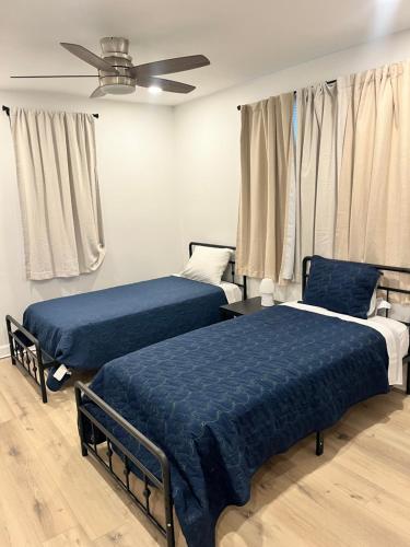 a bedroom with two beds and a ceiling fan at Mid City Canal st 2 bedroom cute house in New Orleans