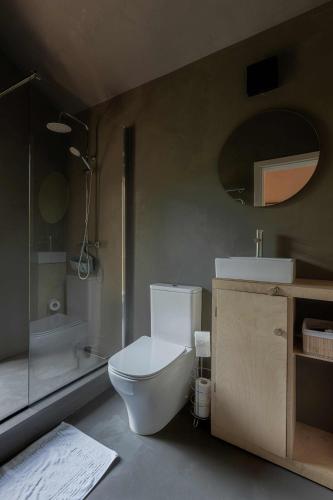a bathroom with a toilet and a sink and a shower at Getlost cabins in Valanciunai