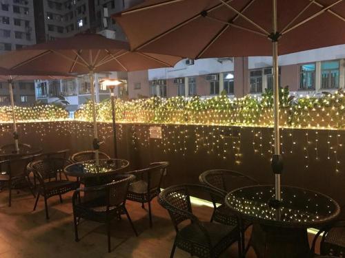 a group of tables with umbrellas on a balcony with lights at Harbour Bay Hotel in Hong Kong