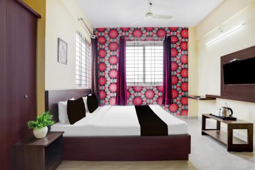 a bedroom with a large bed with a red wall at Super Collection O Summanahalli Bus Stand Formerly Elevate 58 in Bengaluru