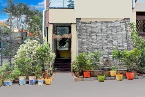 a house with potted plants in front of it at Super Collection O Summanahalli Bus Stand Formerly Elevate 58 in Bengaluru