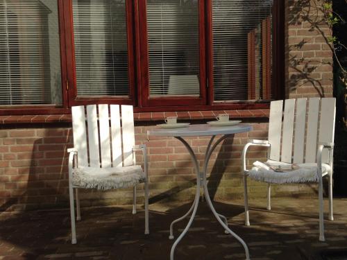 twee stoelen en een tafel voor een gebouw bij Hofje7 in Groesbeek
