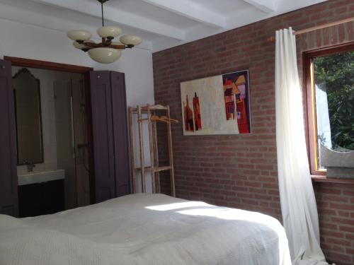 een slaapkamer met een bed en een bakstenen muur bij Hofje7 in Groesbeek