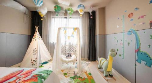 une chambre d'enfant avec un berceau et une aire de jeux dans l'établissement Jinjiang Inn Suqian Xiangwang Hometown Xingfu South Road, à Suqian