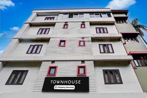 a tall white building with a sign on it at Super Townhouse Guwahati Railway Station Formerly Niharika Guest House in Guwahati