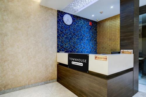 a hotel lobby with a clock on the wall at Super Townhouse Guwahati Railway Station Formerly Niharika Guest House in Guwahati