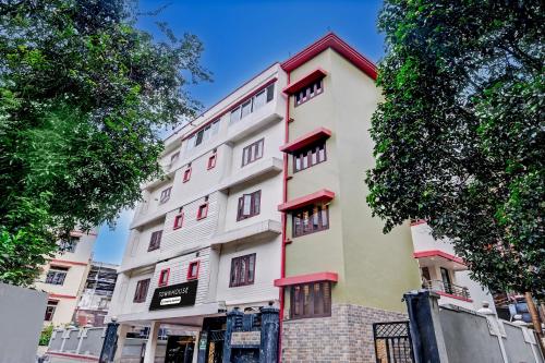 a tall white building with red accents at Super Townhouse Guwahati Railway Station Formerly Niharika Guest House in Guwahati
