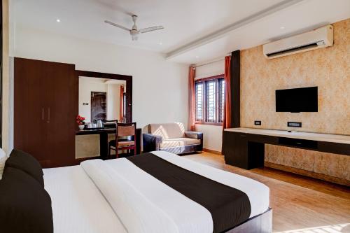 a hotel room with a bed and a television at Super Townhouse Guwahati Railway Station Formerly Niharika Guest House in Guwahati