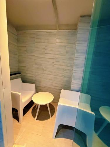 a small room with a table and a table and chairs at Grand Lord Hotel & Residence - Khao chi chan Pattaya in Na Jomtien