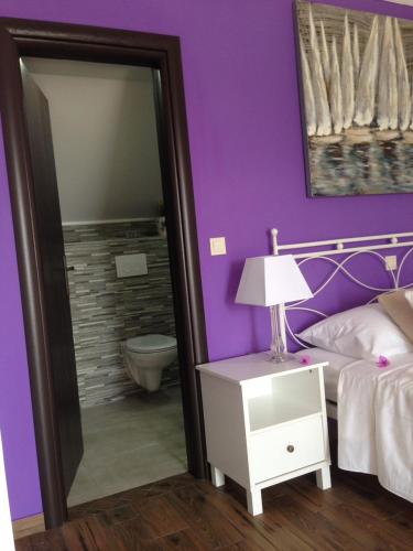 a purple bedroom with a bed and a mirror at Apartments Sabioncello in Orebić