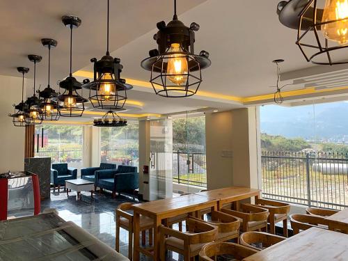 a dining room with a table and chairs and windows at 29 Eleven bed and breakfast in Bungmati