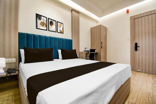 a bedroom with a large bed in a room at Super Townhouse Bairhana Road Prayagraj in Colonelganj