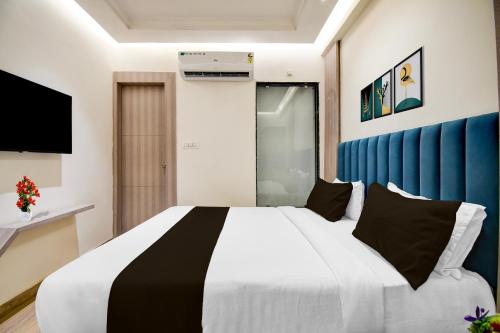 a bedroom with a large bed with a blue wall at Super Townhouse Bairhana Road Prayagraj in Colonelganj