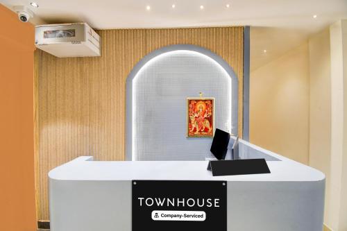 a reception desk in a room with a painting at Super Townhouse Bairhana Road Prayagraj in Colonelganj