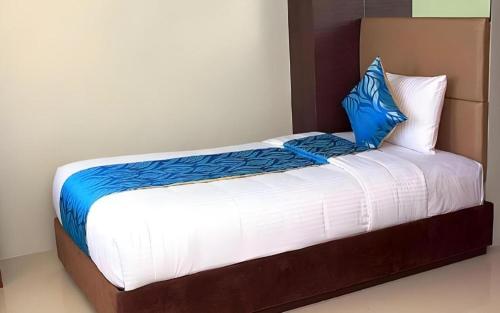 a bed with two blue pillows on top of it at Hotel Estrella in Tacloban