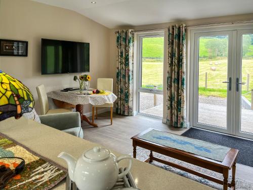 a living room with a couch and a tv at Alderneuk Lodge - Uk49923 in Dumfries
