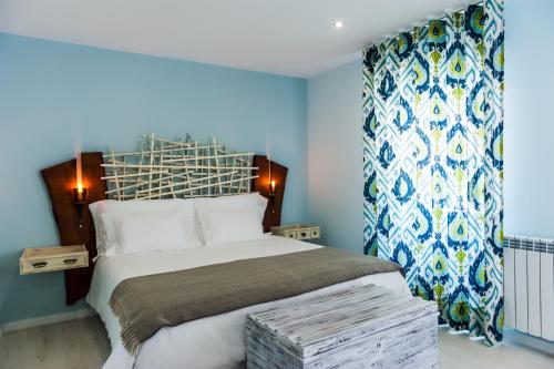 um quarto com uma cama grande e paredes azuis em Casa da Ribeira do Círio em Seia