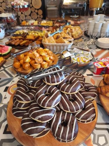 a table with chocolate covered donuts and other foods at Hotel Vojvoda Putnik in Vranje