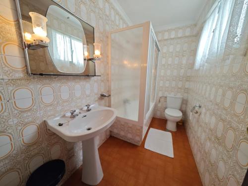 a bathroom with a sink and a mirror and a toilet at Panxon, Arquitecto Palacios, piso con terraza in Nigrán