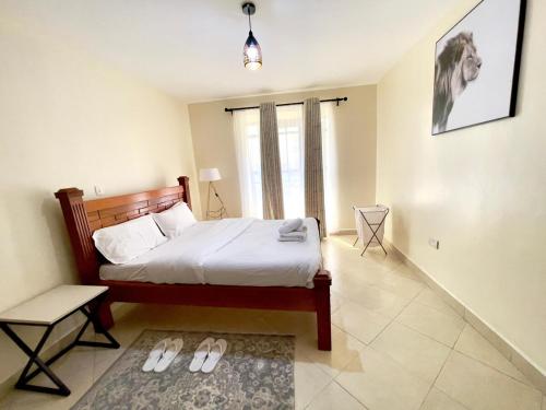 een slaapkamer met een bed en een paar slippers bij Sweethaven in Nairobi