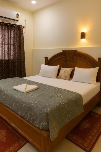 a bedroom with a large bed with white pillows at Vinayaka Heritage in Patna