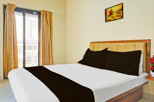a bedroom with a large bed with a window at Super Townhouse Amanora Park Town Formerly Samrat Inn in Pune