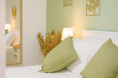 a bedroom with a white bed with green pillows at Alice al Mare in Pescara