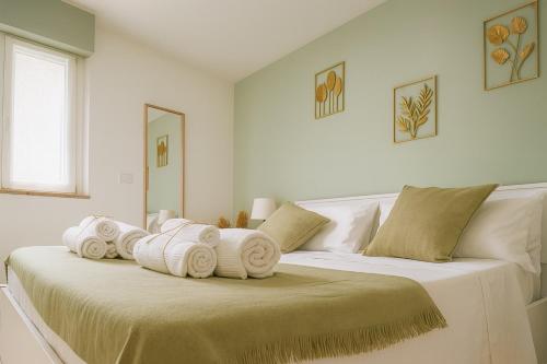 a white bedroom with two beds with towels on them at Alice al Mare in Pescara