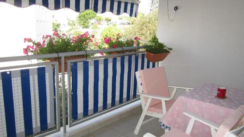 un balcón con una valla azul y blanca y una mesa y una silla en Apartment Marija, en Split