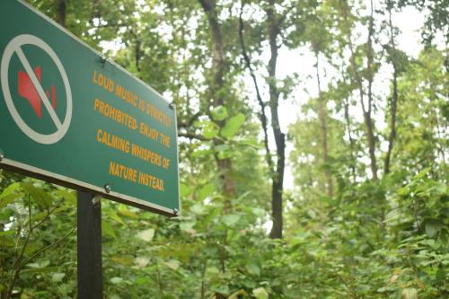 a green sign in the middle of a forest at Athulyam Kanha, kanha national park, mukki gate in Khāpa