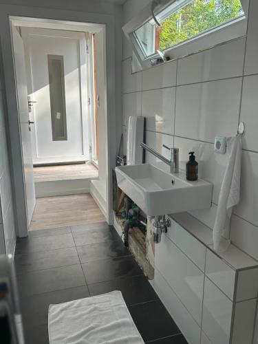 a bathroom with a white sink and a window at Naturhaus am Weiher in Hülsen