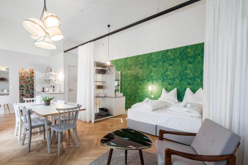 a bedroom with a bed and a dining room at grätzlhotel Karmelitermarkt in Vienna